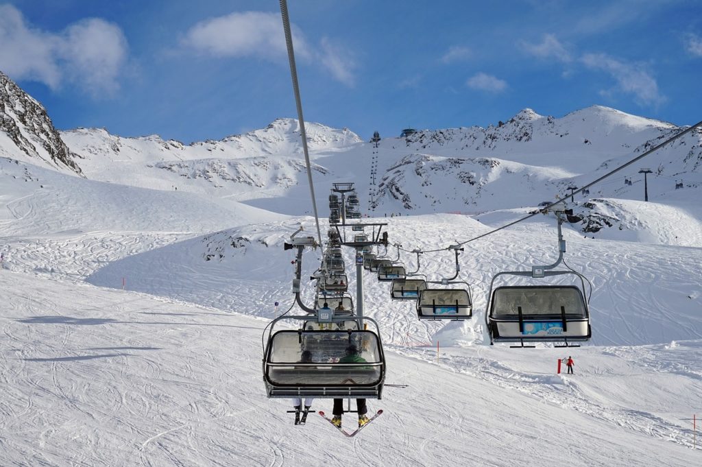 ski resort with chairlift full of skiers.