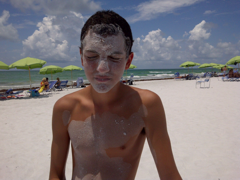 boy covered with the famous powdery white sand of Sarasota