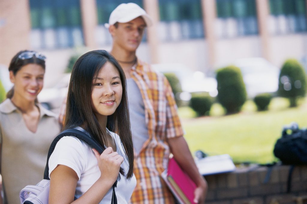 Group of teenagers, college sudents, hanging around outdoors.