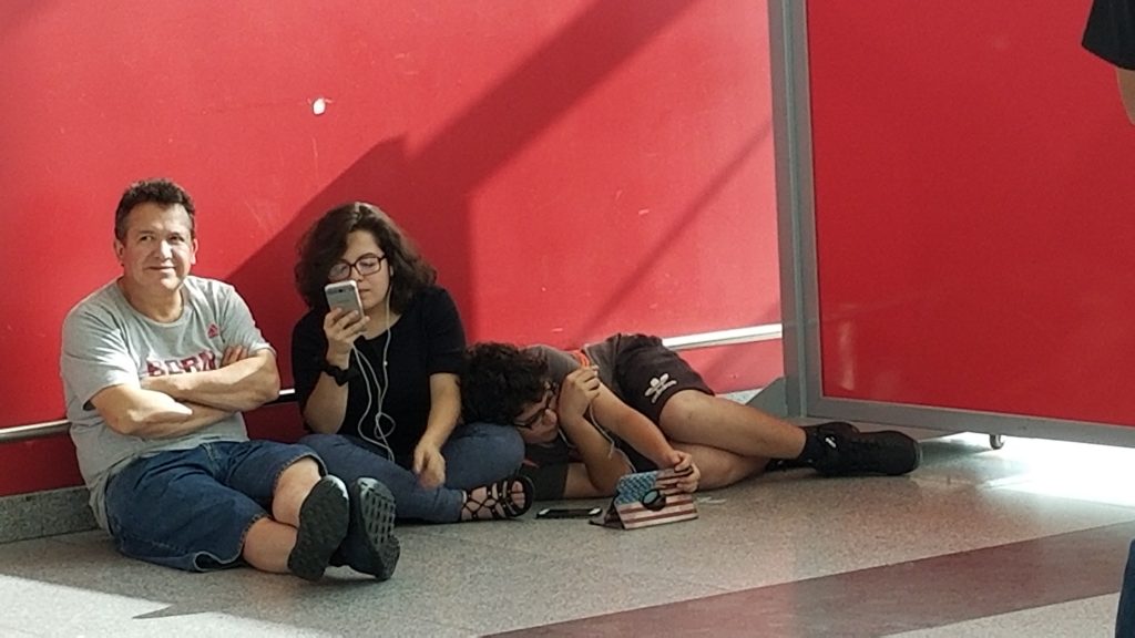 Family waiting on airport floor.