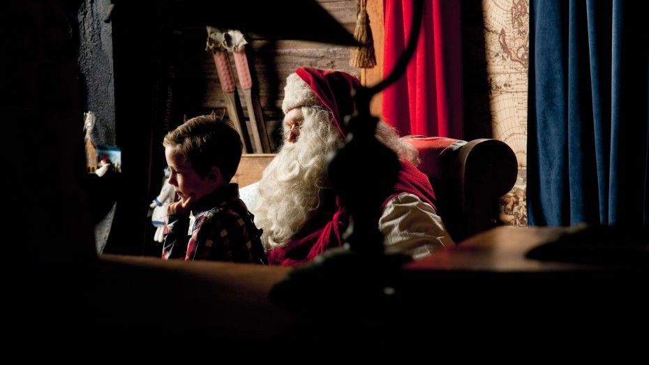 Boy sitting with Santa in Finnish Lapland