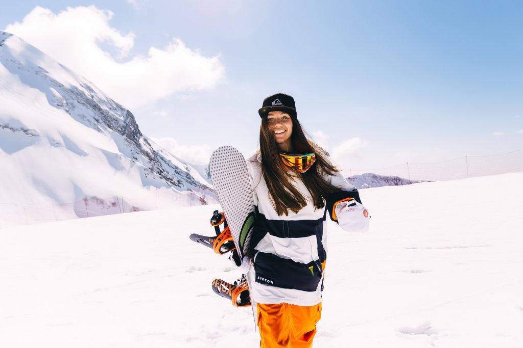 girl with snowboard on mountain