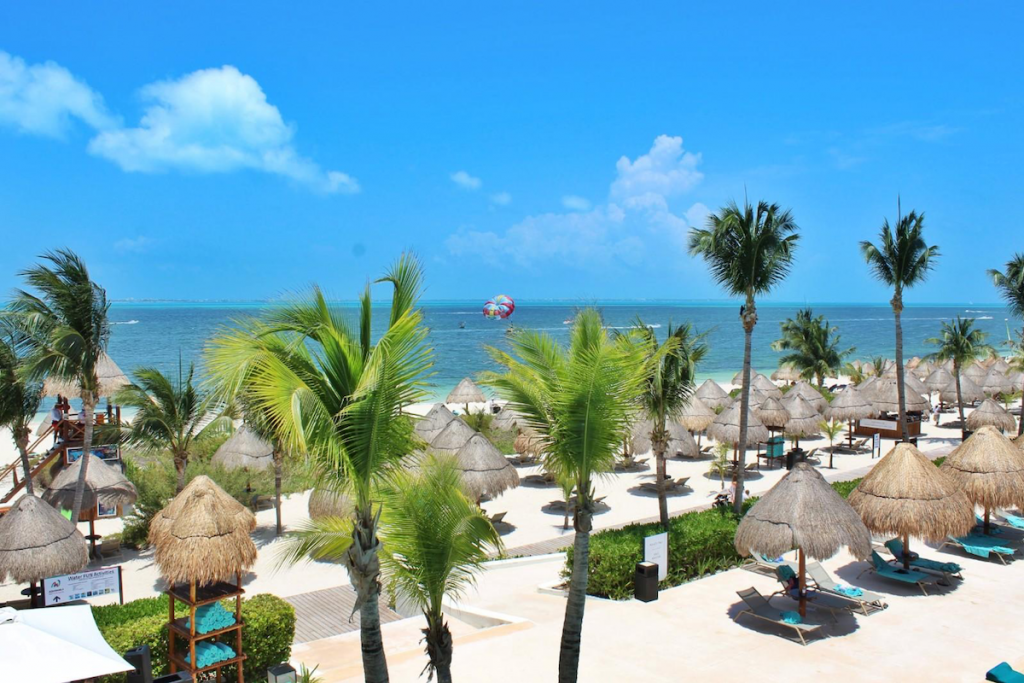 Thatch umbrellas and beach chairs at Finest Playa Mujeres