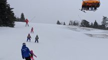Ski school lesson at Okemo with Sunburst 6 Bubble lift overhead