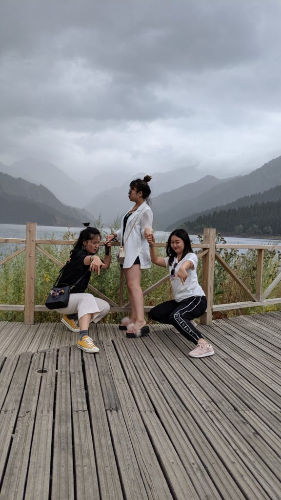 Chinese influencers posing in front of Heavenly Lake and Tian Shan.