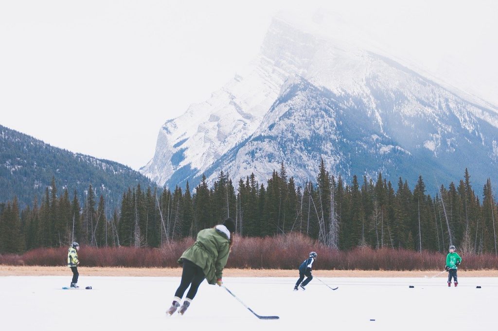 Playing hockey outside on a frozen lake.