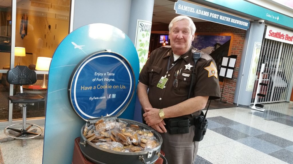 State Trooper distributes chocolate chip cookies at Fort Wayne Airport.