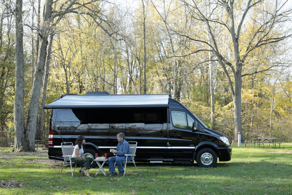 Couple dining in front of Type B Motorhome.