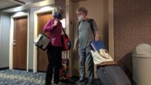 Couple in face masks at hotel elevator