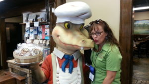 Woman poses with Alligator statue in Gift shop along the Boudin Trail of Southwest Louisiana.