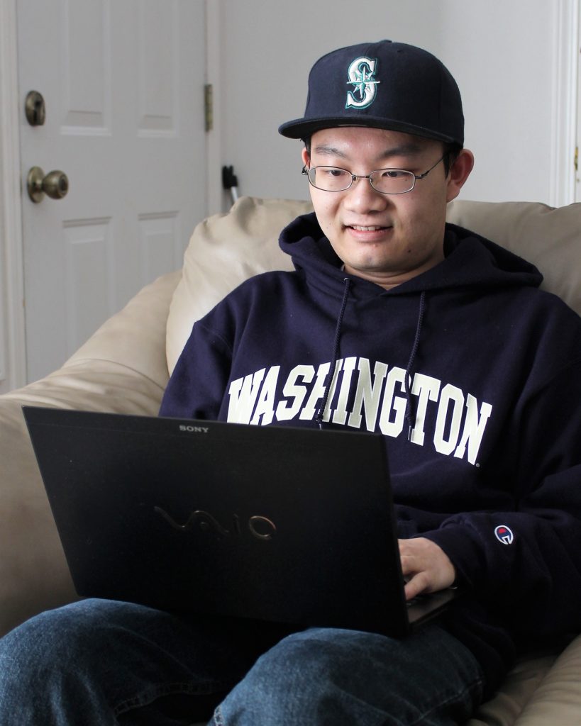 Student in Washington sweatshirt searching on computer