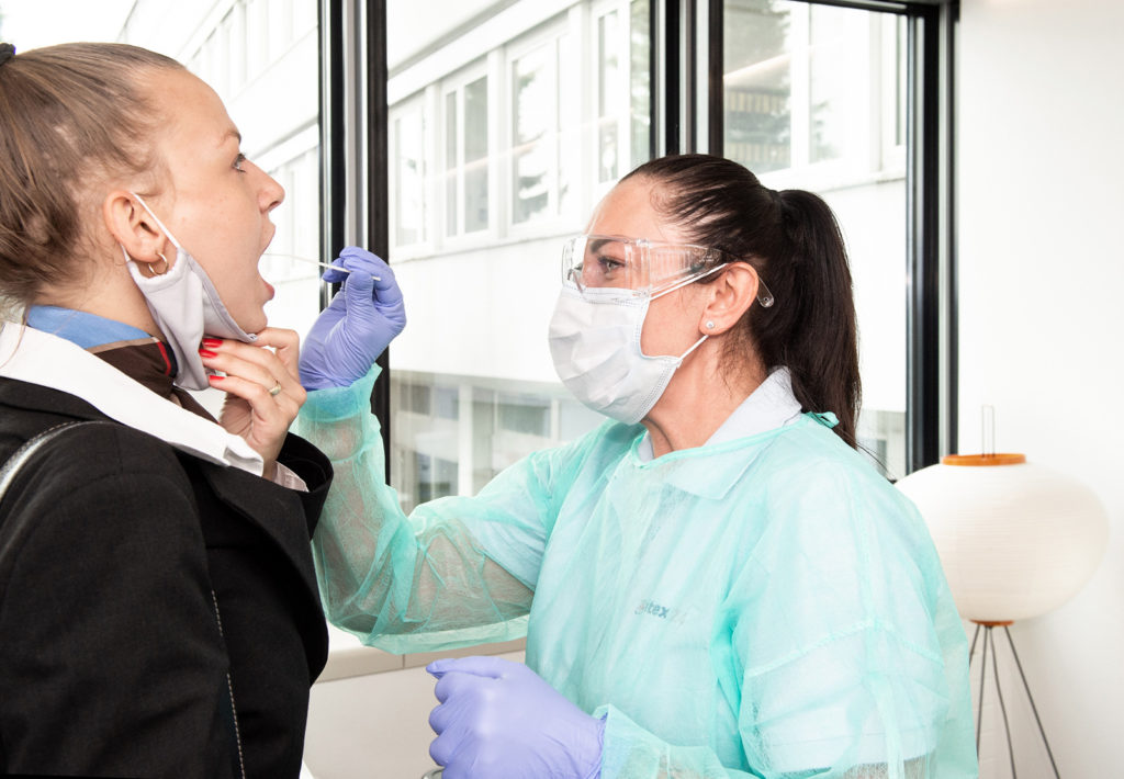 Swissair flight attendant gets COVID-19 antigen rapid test at airport.