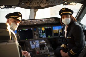 Airline pilots wear face masks in the cockpit of a United flight.