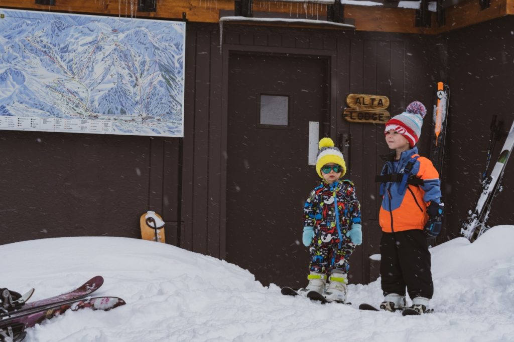 Kids wait in snow gear outside Alta Lodge Utah.