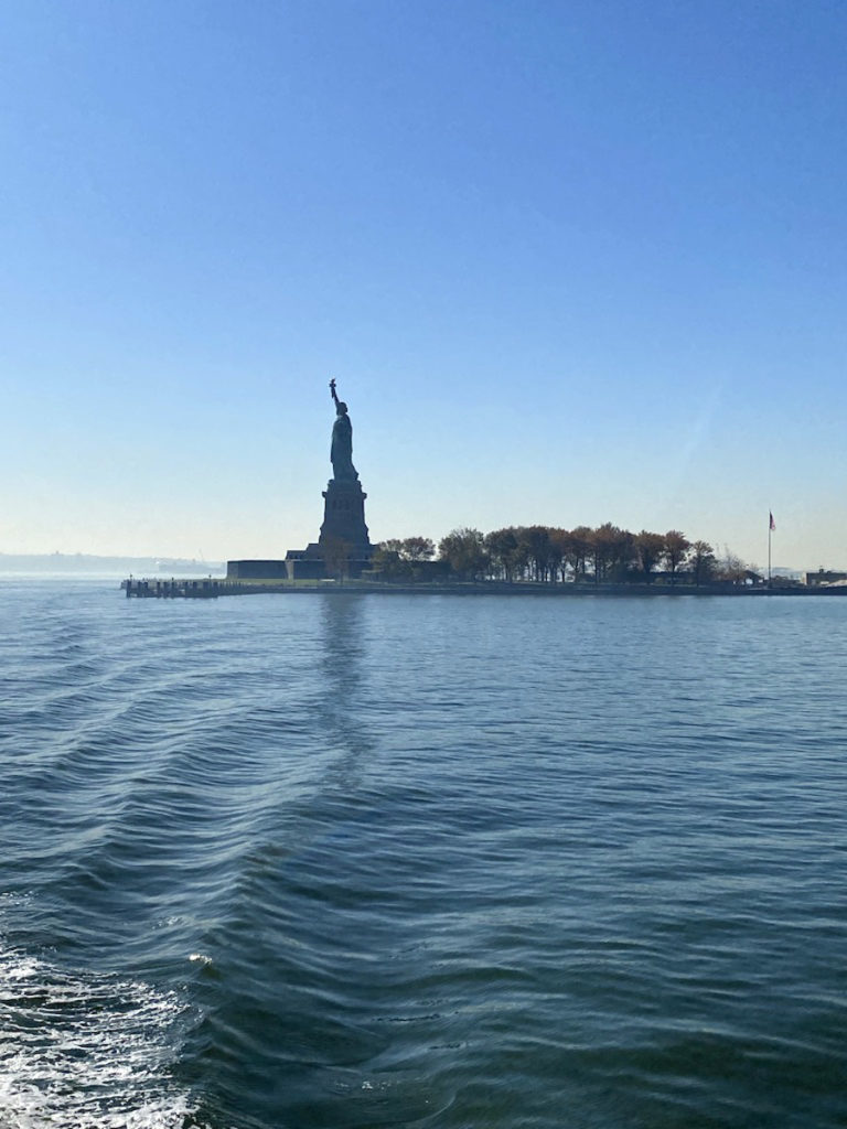 Statue of Liberty seen in the distance from the water.