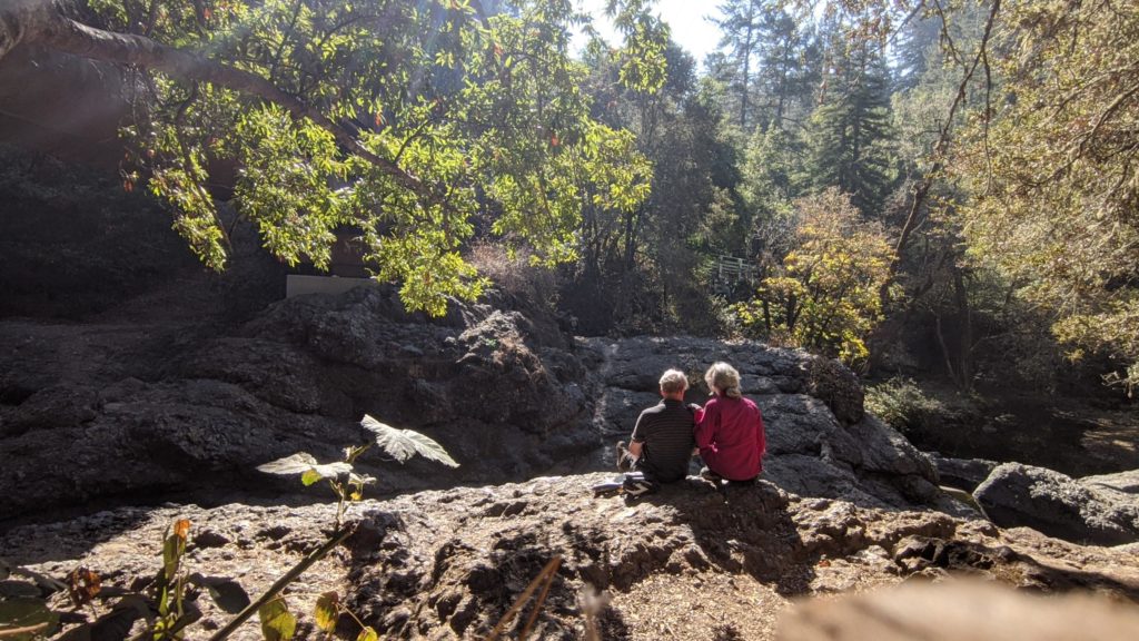 Couples sits on rocks in Taylor State Park, Marin Headlands, California.