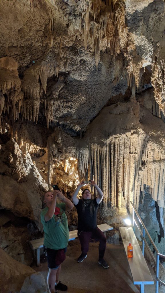 Two boys taking pictures of ceiling at Lake Shasta Caverns in Redding, California.