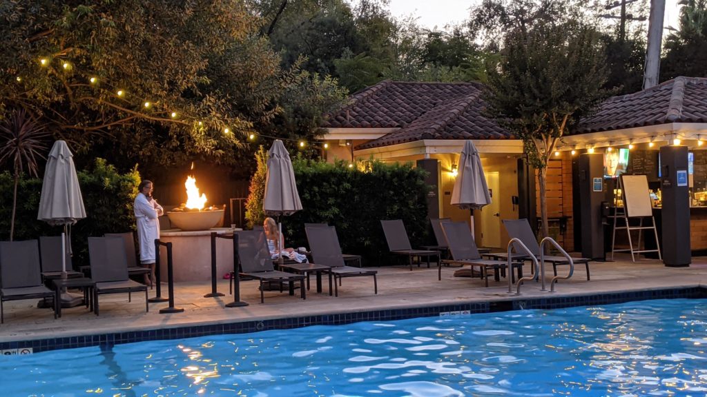 People in bathrobes by the fire pits at Fiarmont Sonoma Mission Inn mineral water pool.