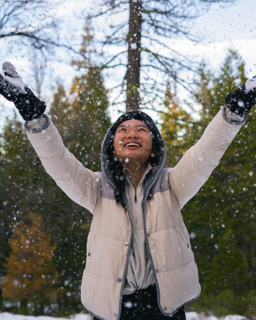 Girl playing with snowflakes outdoors.