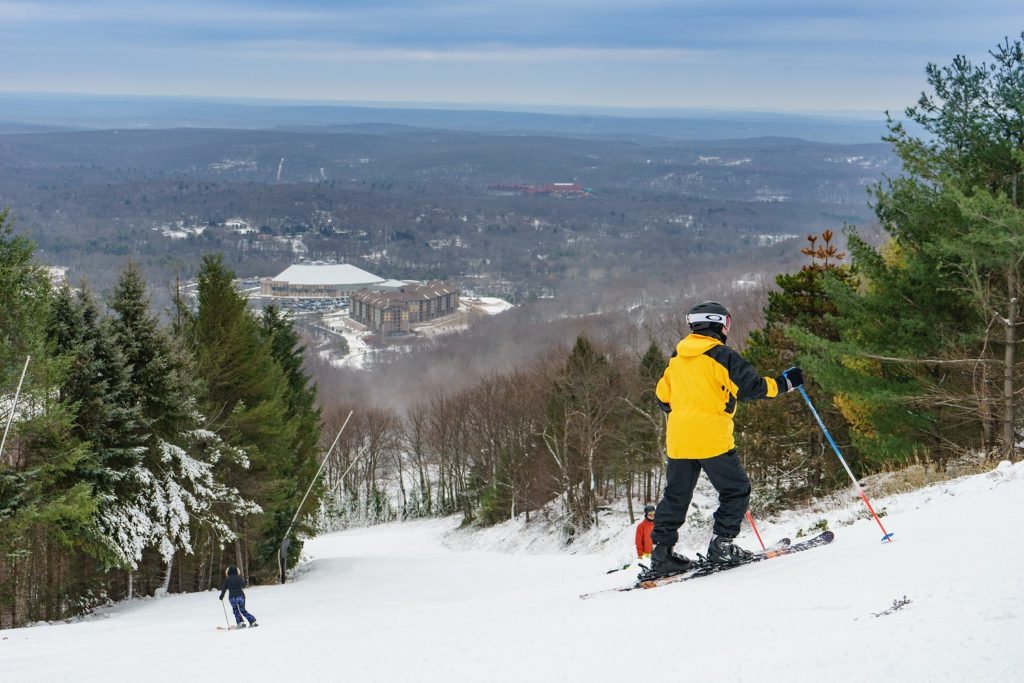 Skier looking down the slopes at base village of Camelback Resort in the Poconos.