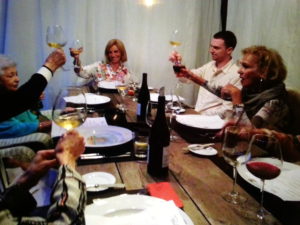 Festive group toasting with wine at a dinner table.