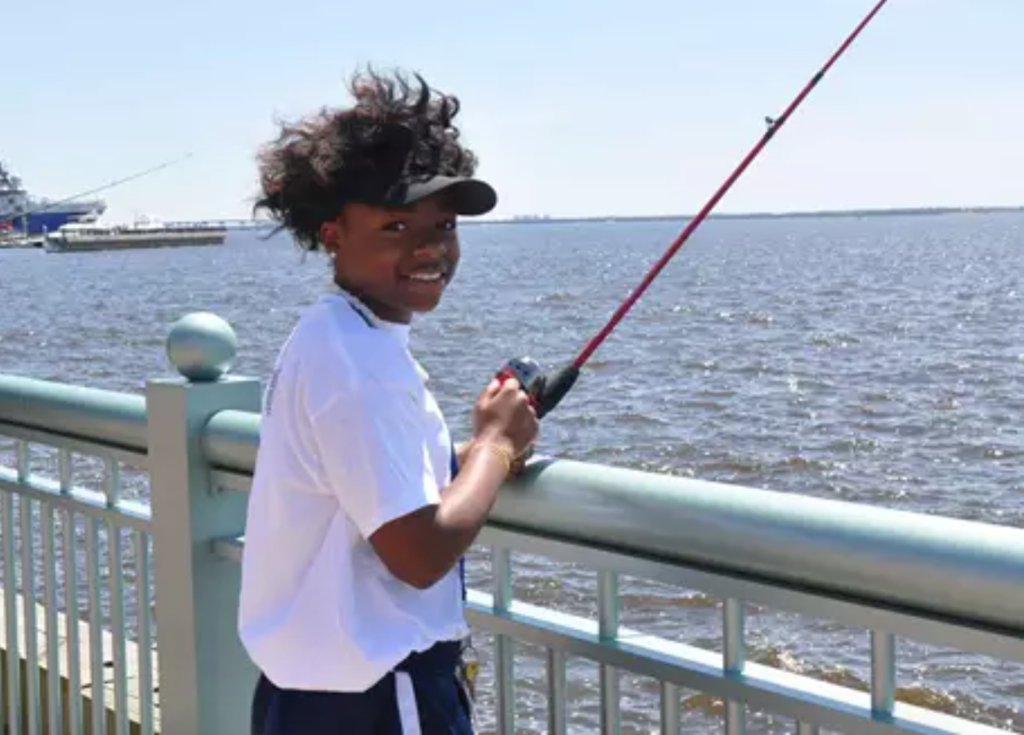 Girl with fishing rod on a pier with Kids Fish Camp