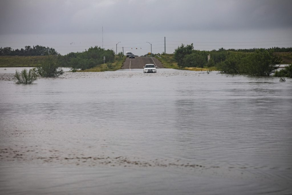 Single car stuck on flooded street after hurricane.