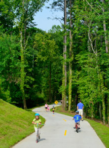 Kids on scooters and bikes in Brook Run Park, Dunwoody, Georgia