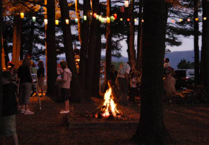 People around bonfire at lake, Sunny Hill Resort, Catskills Mountains, New York