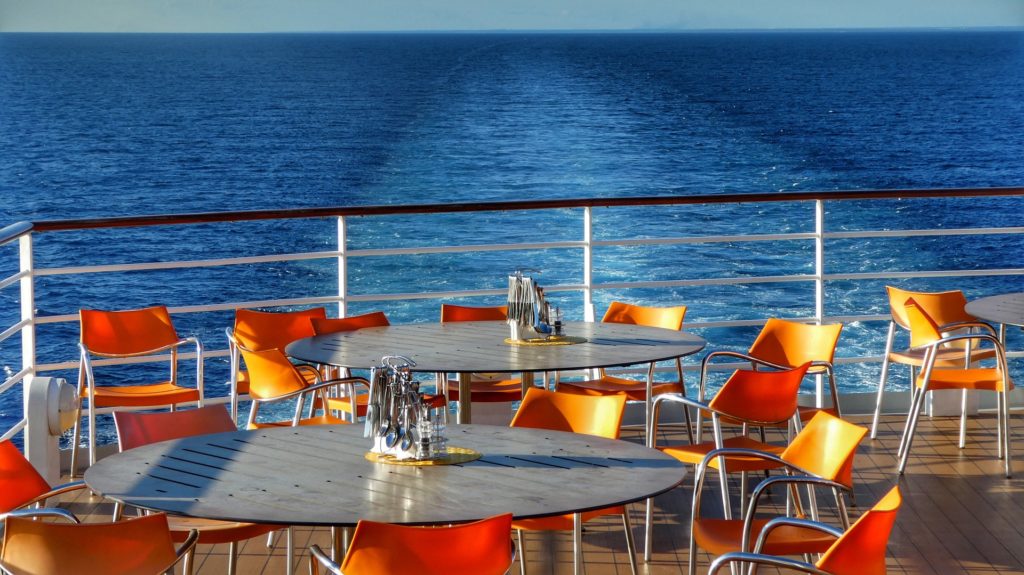 Back deck of a cruise ship set up with tables and chairs.