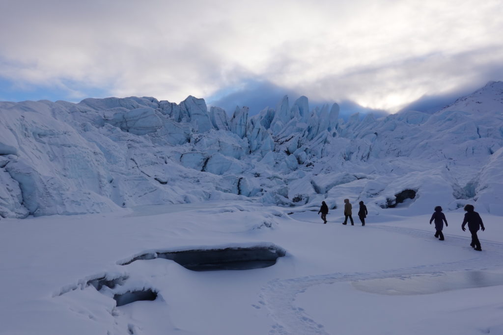 Hikers approach the blue ice Matanuska Glacier to explore its crevasses and caverns.