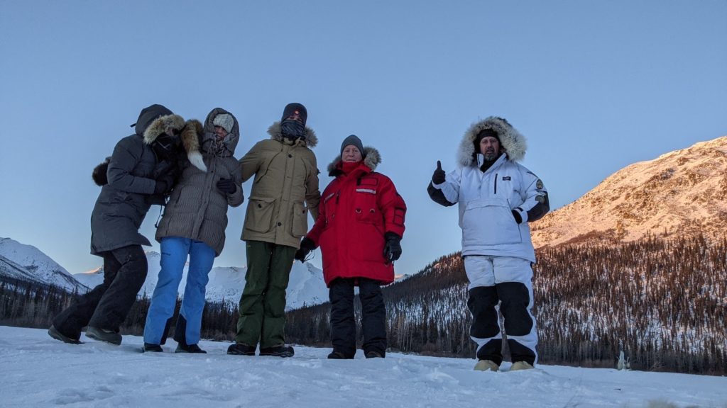 Group of five people in heavy outerwear pose for picture at Brooks Range, Alaska.