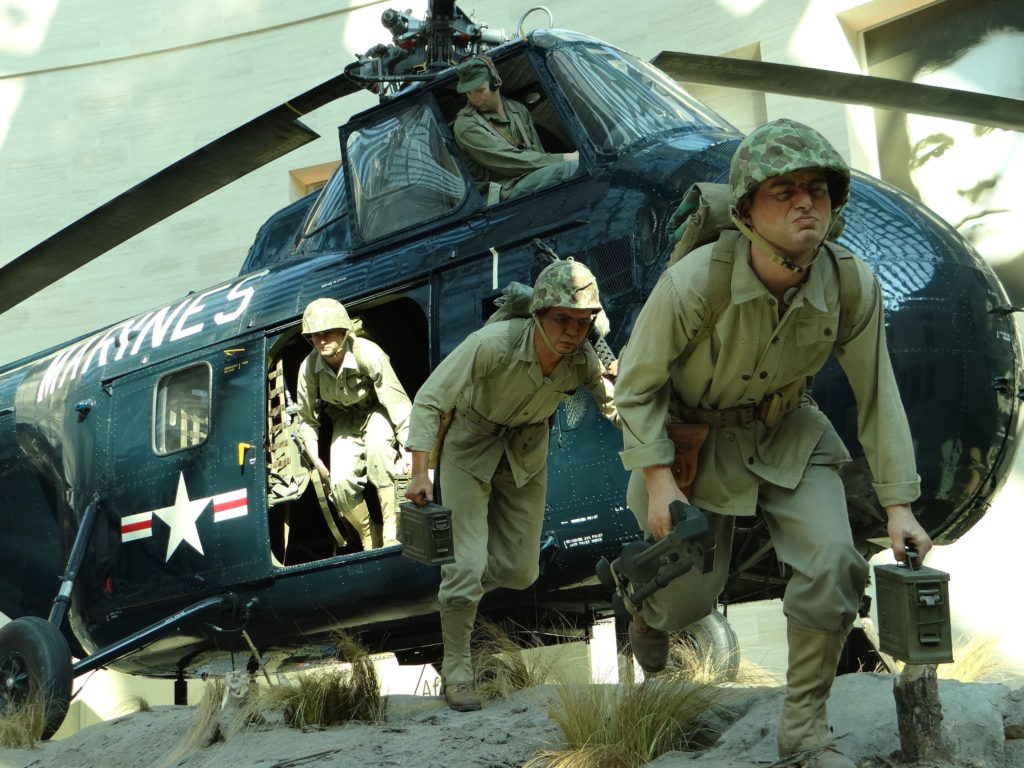 Marine helicopter and costumed troops hitting the beach in a display at the Marine Corps Museum.