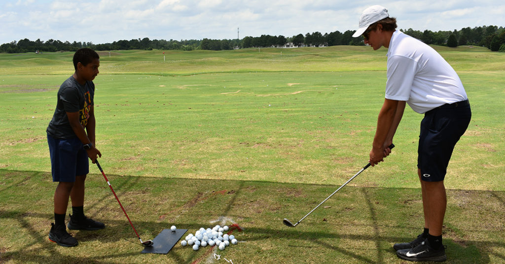 Teen taking a lesson from a pro at Classic Swing Golf School in Myrtle Beach.