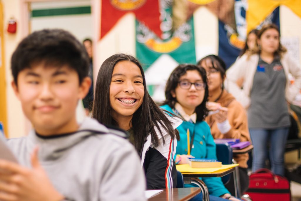 Smiling students sit in classroom