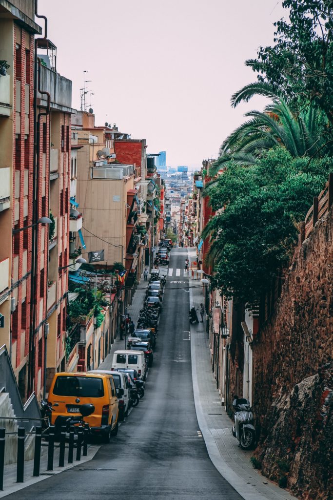 View looking downhill on a narrow street to the skyline of Barcelona, Spain.