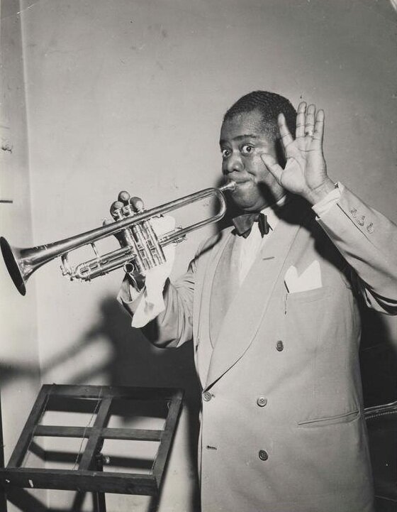 Black and white photo of Louis Armstrong playing trumpet in 1950 from New Orleans Jazz Museum collection.