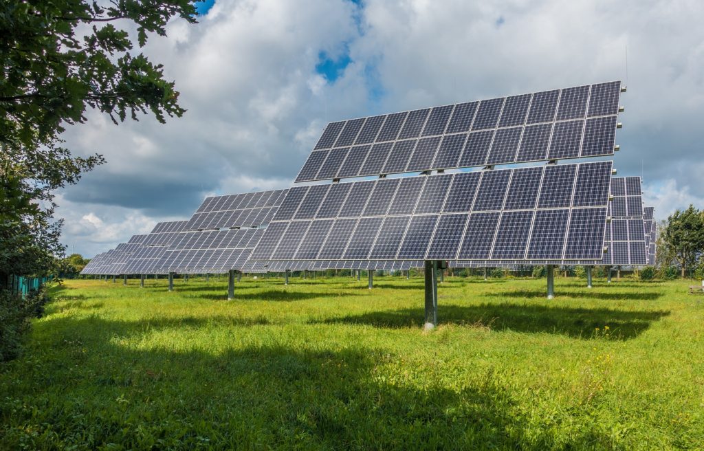 Solar panels on a field in the countryside contribute electricity by storing light from the sun.