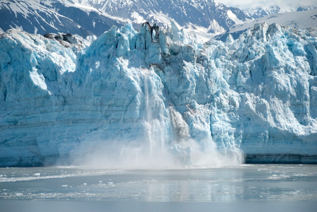 Calving glacier in Alaska tumbles into the bay below.