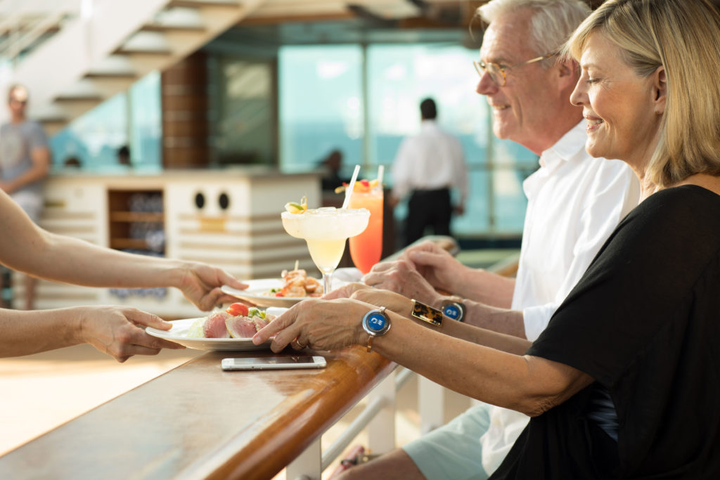 Couple being served food at the Here & Now Then & There snack bar onboard a Princess Cruise ship.
