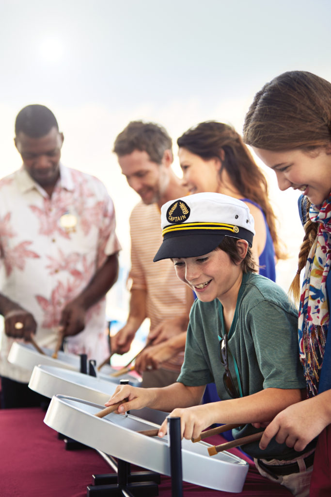 Boy and family learn how to play steel pan drums on a Princess Cruises Festivals of the World event.