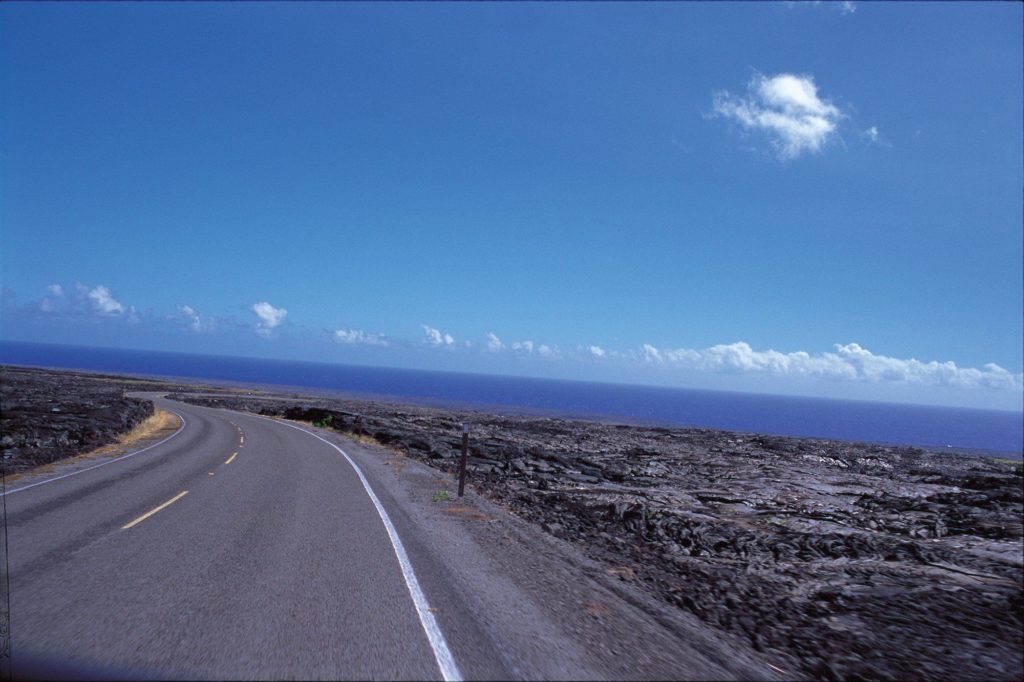 A roadway llined with lava fields on the Big Island of Hawaii.
