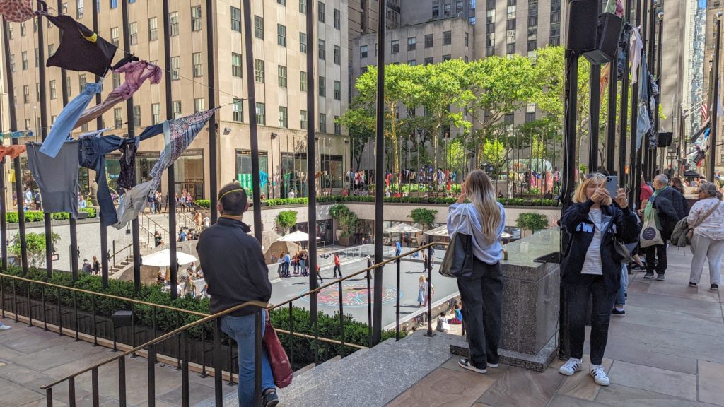 Tourists take pictures and watch skaters at Rockefeller Center in New York.