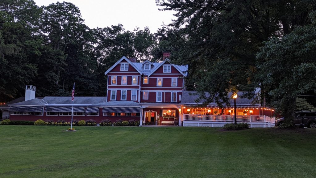 Exterior of historic, 19th-century red clapboard Springside Inn across from Lake Owasco in Auburn, New York
