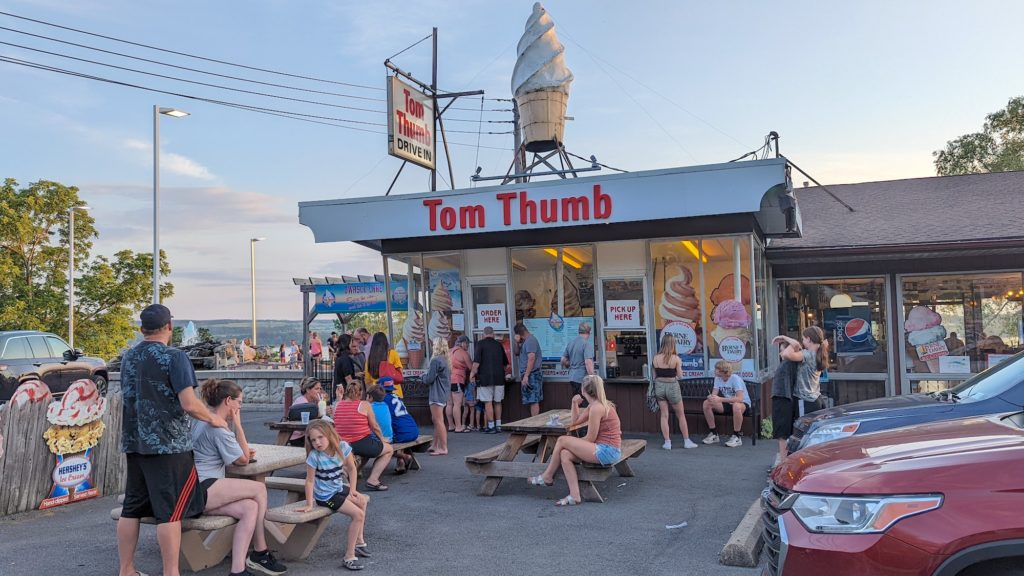 Crowd waits at picnic tables outside Tom Thumb Drivein overlooking Owasco Lake in Auburn, NY.