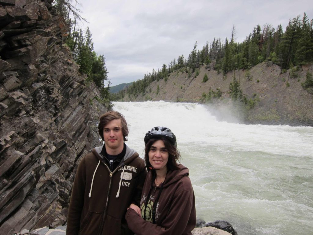 Boy and mom stand in front of river in Canadian Rockies.