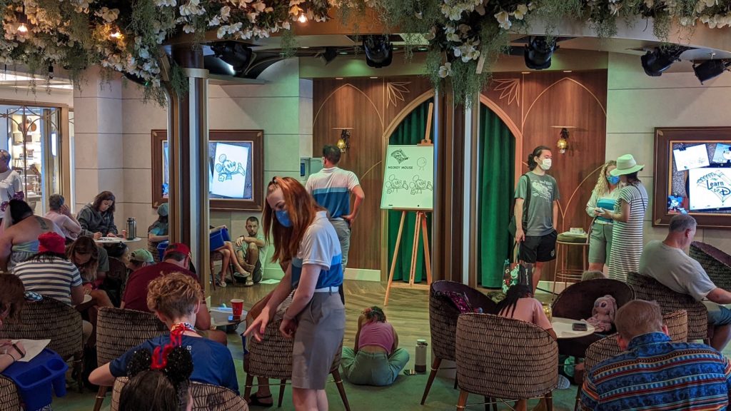 People taking drawing class in Bayou Lounge aboard the Disney Wish cruise ship.