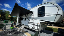 A portable patio setup outside a Cougar model RV home parked at KOA Harpers Ferry, West Virginia.