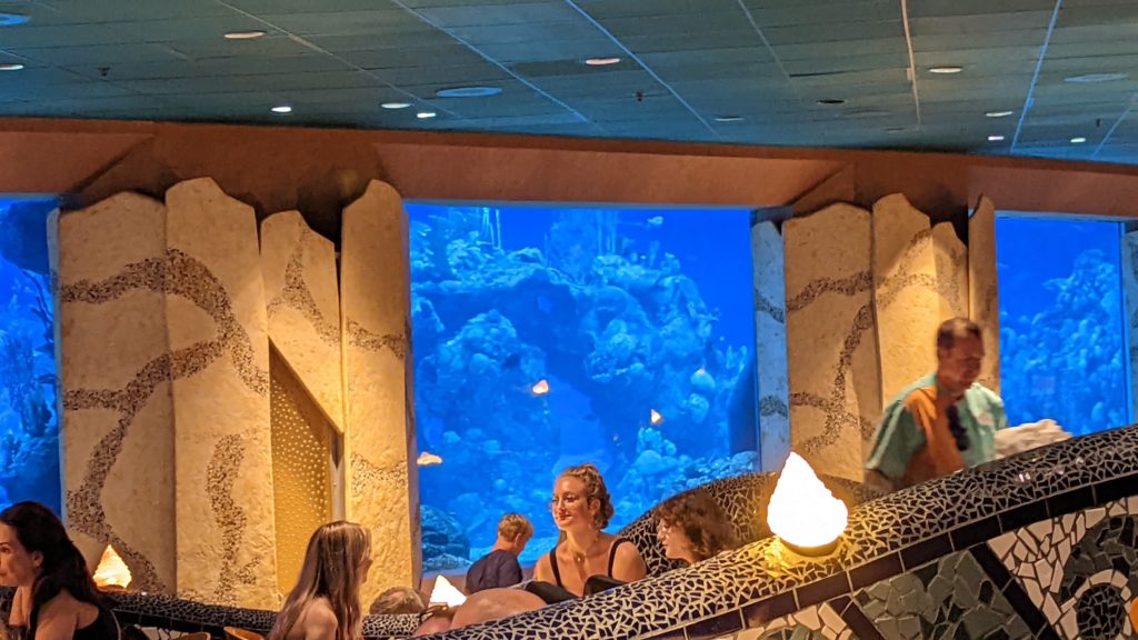 People sitting inside a restaurant in an aquarium at Epcot.