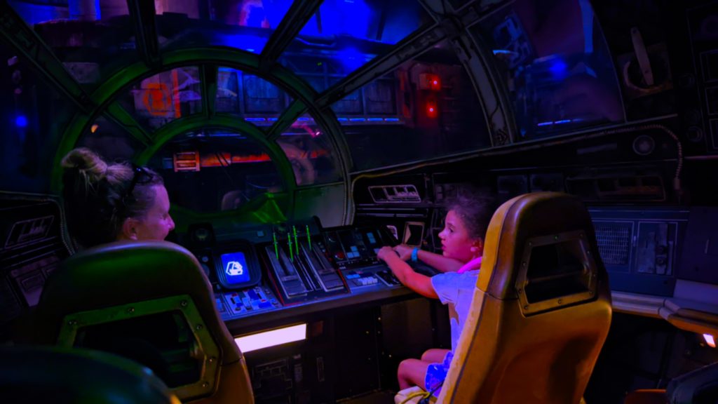 Mom and daughter at the controls of the Millennium Falcon on Smuggler's Run ride at Walt Disney World.